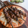 Xinjiang-style lamb skewers over juice-absorbing flatbread.