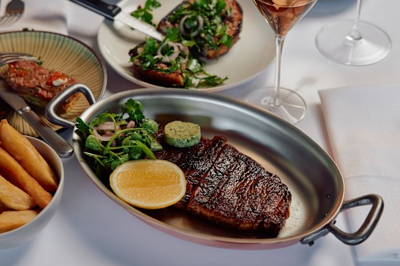 Black angus steak with herb butter, and bone marrow on toast (rear).