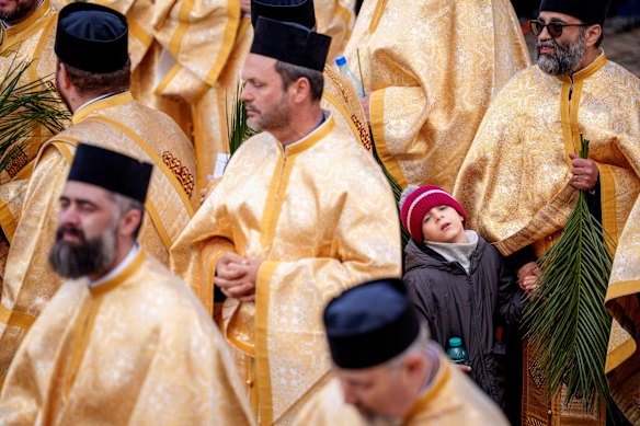 A child stands among priests outside the Patriarchal Cathedral after an Orthodox Palm Sunday pilgrimage in Bucharest, Romania.