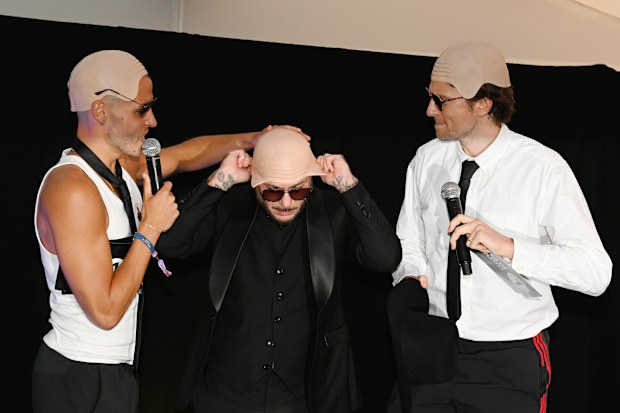 Pitbull (C) is presented with the Guinness World Record title for the ‘largest gathering of people wearing bald caps’ alongside BBC Radio 1 presenters Dean McCullough (L) and Greg James 