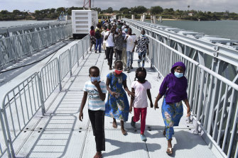 Members of the public walk across the newly commissioned Liwatoni floating foot bridge in Mombasa, Kenya, on New Year’s Day. It was built the Kenyan National Highway Authority through the China City Construction Company.