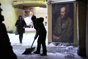 A worker clears snow from a portrait of Fyodor Dostoevsky on a wall near the apartment-museum where he lived in St Petersburg.