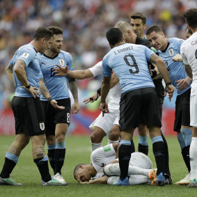 Someone find that sniper: Uruguay players fume after they believe France's Kylian Mbappe (on the ground) dived.