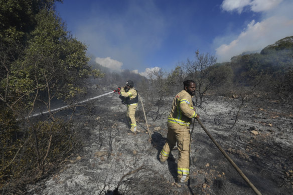 Israeli firefighters work to extinguish a fire after a rocket fired from Lebanon hit an open field in northern Israel, on Wednesday.