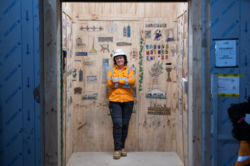 Going up: Lift operator at Anzac railway station construction site Melody Forrester with her underground art gallery.