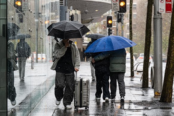 Pedestrians brave the wet and windy weather on Goulburn Street in the Sydney CBD.