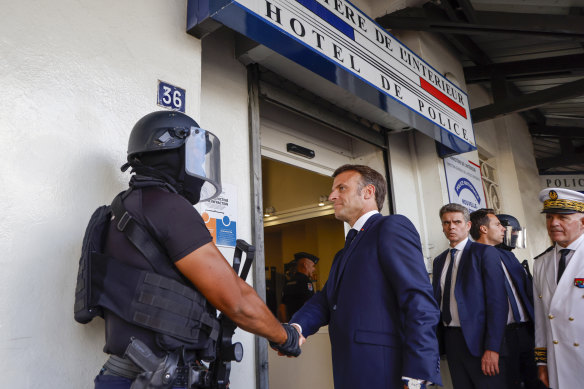 French President Emmanuel Macron shakes hands with a policeman upon his arrival at the central police station in Noumea, New Caledonia, on Thursday.