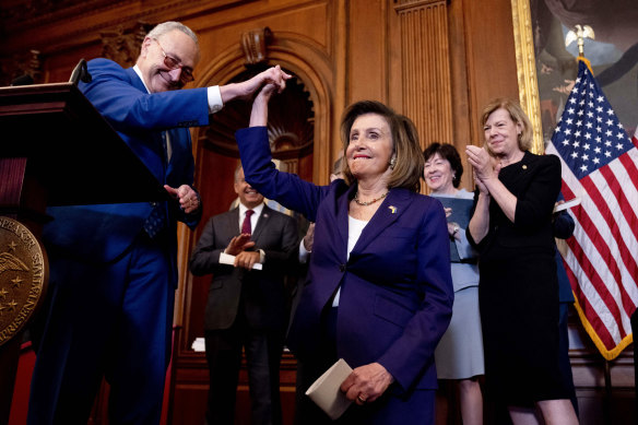 Senate Majority Leader Senator Chuck Schumer of NY, left, high-fives House Speaker Nancy Pelosi, as he praises her before she signs the Respect For Marriage Act in Washington.