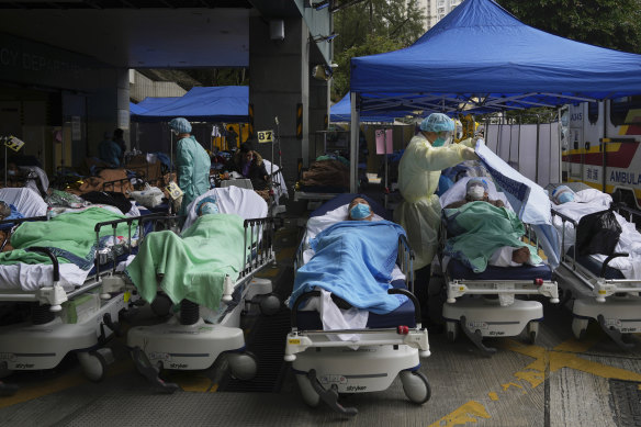Patients lie on hospital beds as they wait at a temporary makeshift treatment area outside Caritas Medical Centre in Hong Kong on Friday.