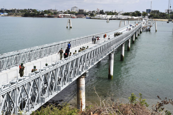 People walk across the newly commissioned Liwatoni floating footbridge in Mombasa, Kenya, another project financed and built by China.