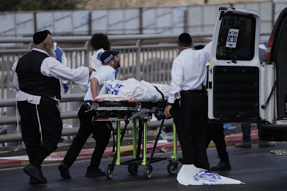 Rescue and recovery workers carry the body of a victim at the scene.