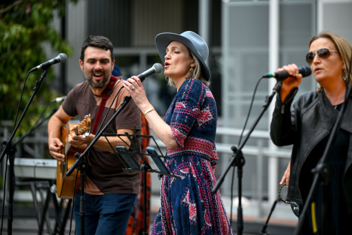 Tay Pappas, centre, flanked by Simon Rashleigh and her sister Zoe Pappas, sings with the St Kilda Primary School parents’ band Primary Scream at a festival at Middle Park primary school on Sunday.