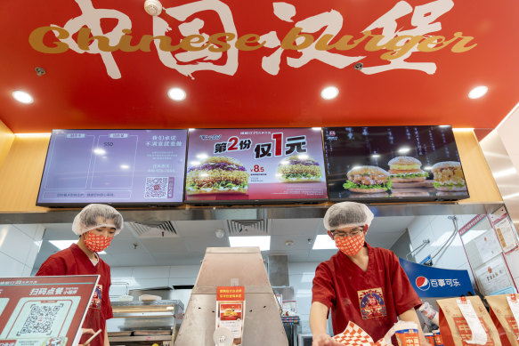 Fast food workers at Chinese burger chain Tastien prepare orders at a store in Beijing.