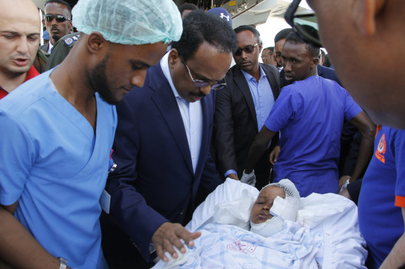 Somalia's President Mohamed Abdullahi Mohamed visits one of the wounded from Saturday's car bomb blast in Mogadishu.