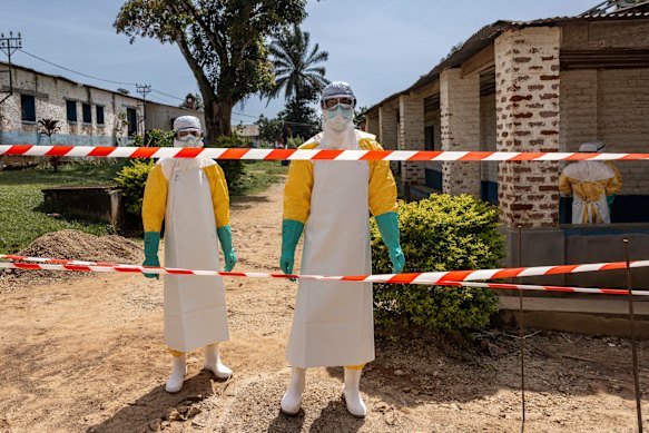 Health workers cross into a restricted area outside an isolation unit at the General Referral Hospital of Mongbwalu last month.