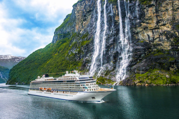 Viking Sky in front of the Seven Sisters Waterfall in Geiranger Fjord, Norway.