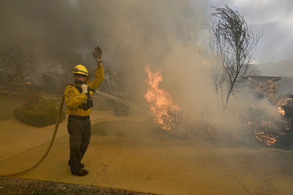 A firefighter asks for more water as his hose goes dry along in Los Angeles.