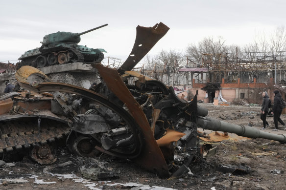 Local residents pass by a damaged Russian tank in the town of Trostsyanets, some 400km east of capital Kyiv, Ukraine.