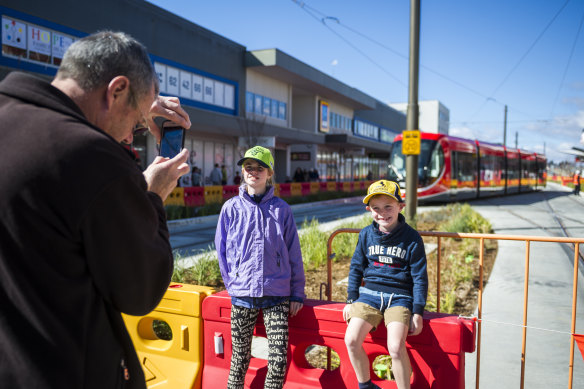 Angelique Corbitt, 10, and James Corbitt, 7, having their photo taken in front of the new tram.
