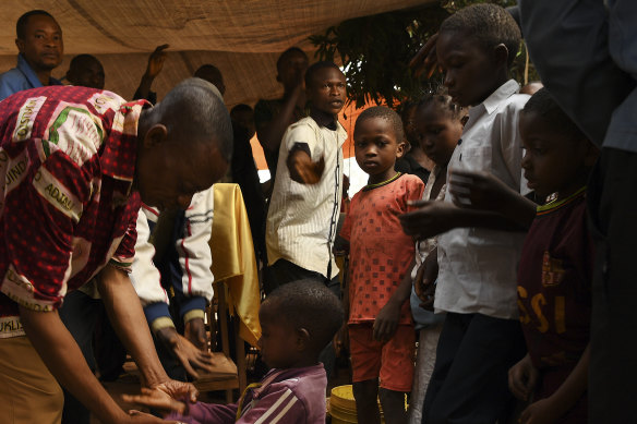 A child receives a blessing from a pastor during a prayer service for children in Kasai Central.