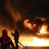 Firefighters extinguish a fire at a factory building that has been engulfed in a wildfire in Uiseong, South Korea on Saturday.