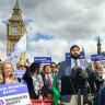 Leader of the Workers Party of Britain George Galloway (right) looks on as former England cricketer Monty Panesar (centre) addresses fellow party candidates in Parliament Square.