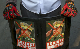 A protester displays a defaced image of military ruler General Min Aung Hlaing.