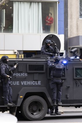 A woman looks on at a police heavy vehicle in the city ahead of protests.