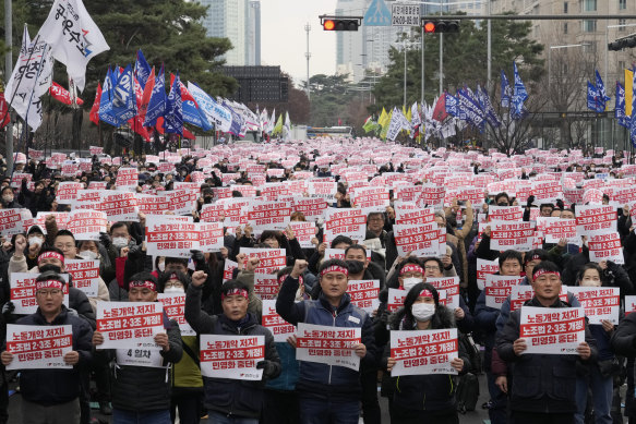 Members of the Korean Confederation of Trade Unions hold up their cards during a rally against the government’s labor policy near the National Assembly in Seoul  in December.