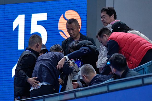 The man who has hit in the face by a ball hit by Novak Djokovic receives assistance in Beijing. 