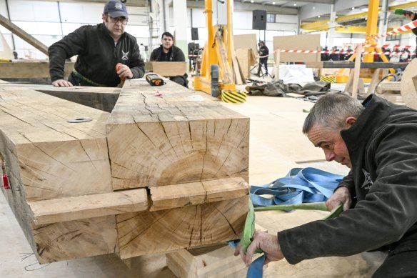 Carpenters work on the wood of a part of the base of the new spire of the Notre-Dame de Paris cathedral, in Briey, eastern France, on March 16.