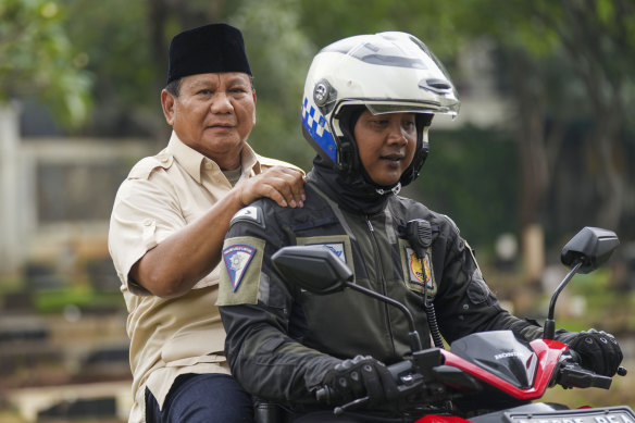 Prabowo Subianto (left) is taken to his father’s grave in Jakarta on Thursday.