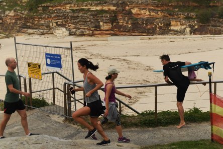 Early morning exercisers squeeze past the fencing on Thursday.