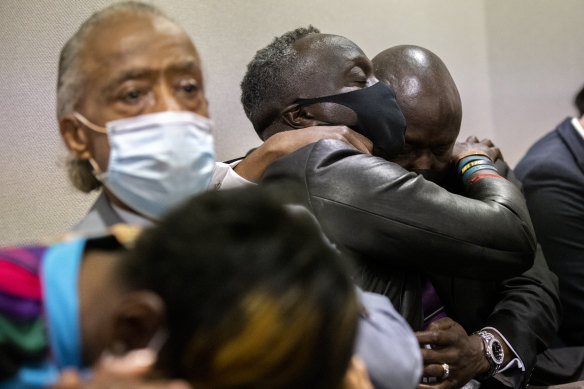 Ahmaud Arbery’s father Marcus Arbery, centre, his hugged by his attorney Benjamin Crump after the jury convicted Travis McMichael in Brunswick, Georgia.