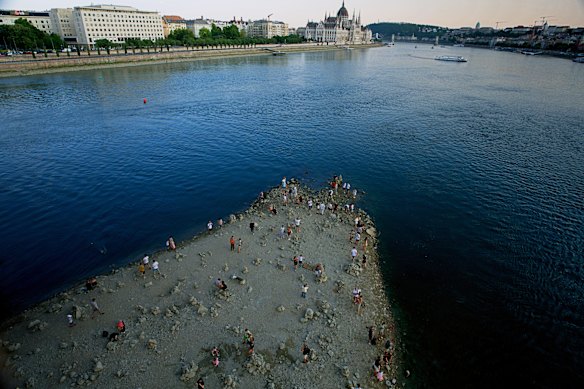 People walk on a sandbar underneath the Danube’s Margaret Bridge in Budapest, Hungary. 