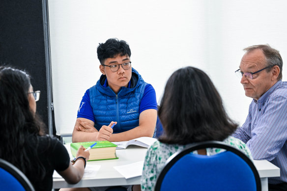 Tutoring student Isaac and sisters Sahana and Amara with English tutor Colin Turner at Topscore Education. 