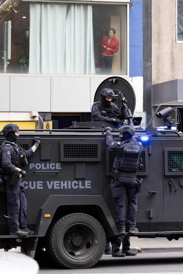 A woman looks on at a police heavy vehicle in the city ahead of protests.