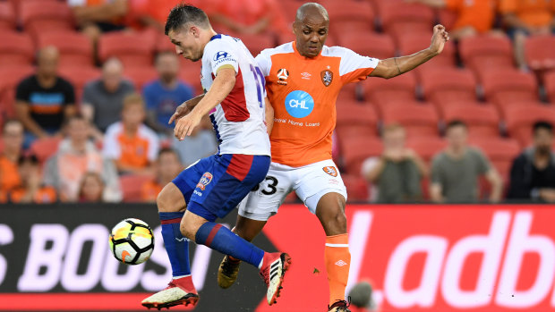 Henrique of the Roar (right) is intercepted by Wayne Brown of the Jets during the Round 21 A-League match between the Brisbane Roar and the Newcastle Jets at Suncorp Stadium on Saturday.