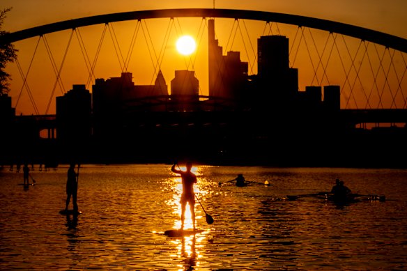 People paddle on the Main river in Frankfurt, Germany.