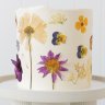 A custom cake decorated with edible flowers.
