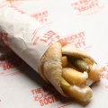 A wrap filled with hot chips, toum (garlic sauce) and pickles.