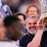 Tottenham’s head coach Ange Postecoglou holds up the trophy.