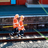 Workers on the Sydenham train station tracks.
