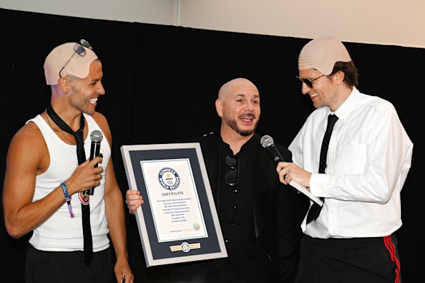 Pitbull (centre) is presented with the Guinness World Record title for the ‘largest gathering of people wearing bald caps’ alongside BBC Radio 1 presenters Dean McCullough (left) and Greg James (right)