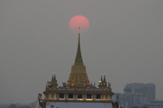 The sun sets behind the golden mount temple in Bangkok, Thailand. 