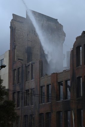 NSW Fire and Rescue workers spray water onto the destroyed building.