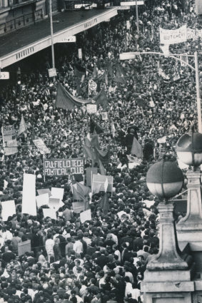 Protesters sit down outside Myer on Bourke Street.