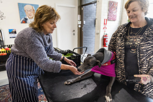 Anne Moloney greets Teisha and her dog, Jean, at the Father Bob Maguire pantry.
