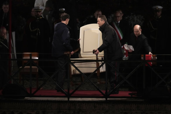 Vatican ushers carry away Pope Francis’ chair prior to the start of the Via Crucis (Way of the Cross) at the Colosseum on Good Friday.