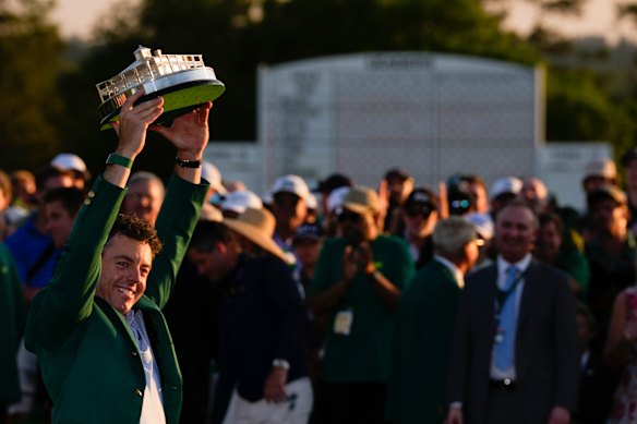 McIlroy lifts the trophy into the air.